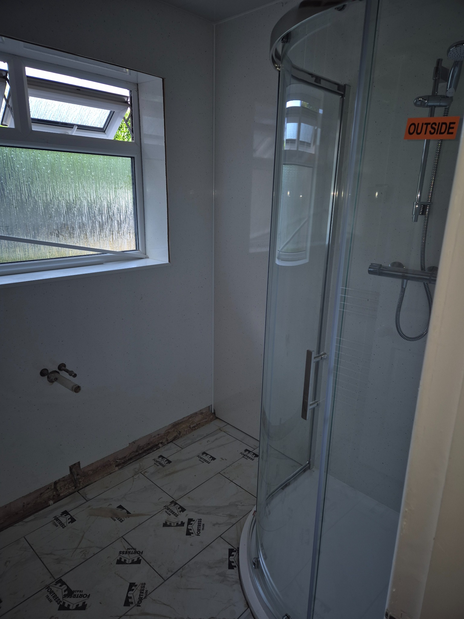 Shower enclosure installed over the prepared wet-area system, showing the protected zone carried through to fitting